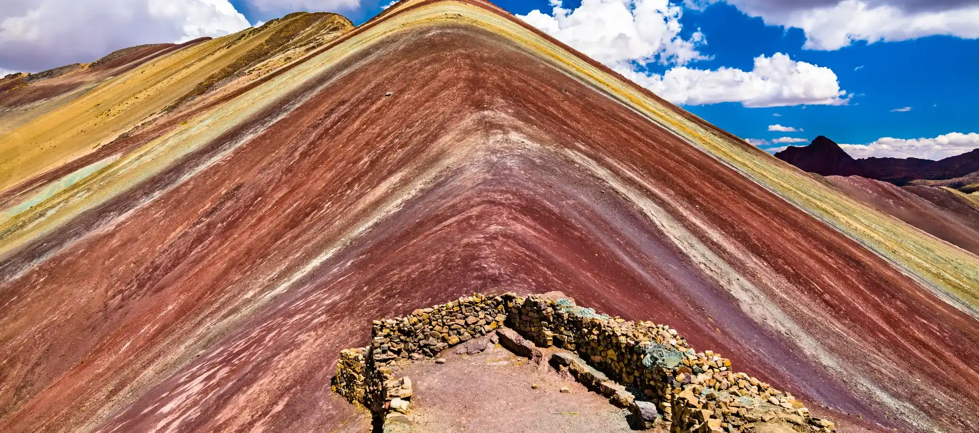 "Cómo visitar la Montaña de Colores desde Cusco 2026: vista panorámica de Vinicunca con sus franjas naturales multicolores en los Andes peruanos